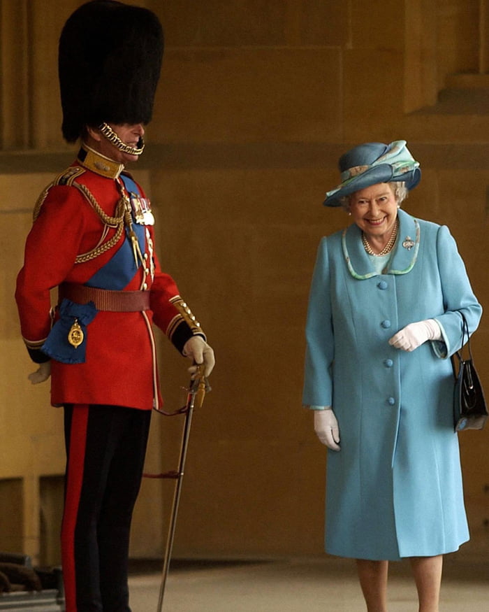 Queen Elizabeth Ii Giggling As She Walks Past Her Husband Prince Philip