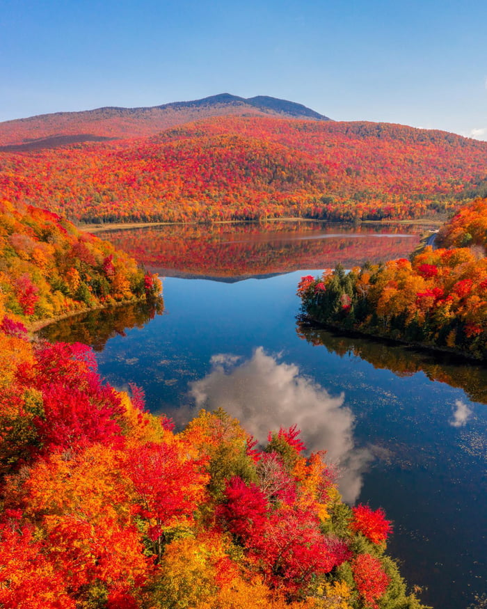 Mountains covered with autumn foliage reflected in Lake Eden in the