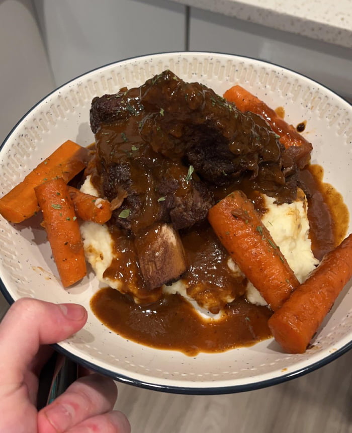 Homemade braised beef ribs, mashed potatoes, carrots, and red wine