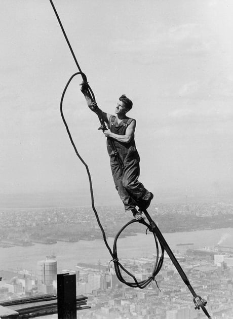 Lewis W Hine. A worker connects two cables during the construction of the Empire State Building (Icarus atop Empire State Building). New York. 1931