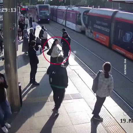A security guard in Turkey saved a woman who was walking carelessly with headphones on from being crushed under a tram at the last moment.