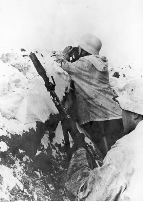 Two German soldiers in winter uniforms in a trench on the Eastern Front.  One of them is holding a Mauser Kar98k rifle equipped with a grenade  launcher. 1943-12 - 9GAG
