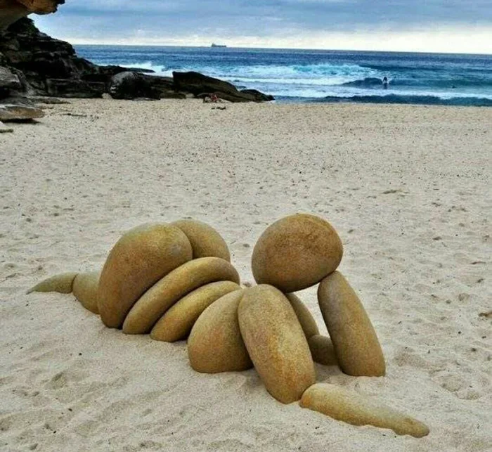 sexy rock beach art, stones in shapely shape in sand